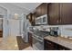 A well-lit kitchen boasting stainless steel appliances, rich dark wood cabinets, and granite countertops at 5475 Elba Way # 1601, Myrtle Beach, SC 29579