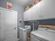 Bright laundry room with white cabinets, washer, dryer, and a door to the main house at 5475 Elba Way # 1601, Myrtle Beach, SC 29579