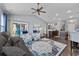 Open-concept living room and kitchen with a large rug, ceiling fan, and plenty of natural light at 5475 Elba Way # 1601, Myrtle Beach, SC 29579