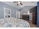 Comfortable bedroom with wood floors, blue walls, dresser, and an open en suite bathroom at 5475 Elba Way # 1601, Myrtle Beach, SC 29579
