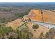 Expansive aerial view of the property featuring a home, barn, ponds, and fields surrounded by lush woodlands at 589 Loop Circle, Longs, SC 29568
