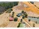 Stunning aerial view of a property featuring multiple ponds, a red barn, and vast open fields at 589 Loop Circle, Longs, SC 29568