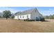 Backyard of the home including back of house, a large yard, and mature trees at 589 Loop Circle, Longs, SC 29568
