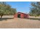 Exterior shot of a red barn with an open doorway, set on a grassy field with scattered trees at 589 Loop Circle, Longs, SC 29568