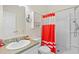 Clean bathroom features a white vanity, toilet, and a shower with a vibrant red shower curtain at 589 Loop Circle, Longs, SC 29568