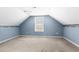 Upstairs bedroom features neutral carpet, a window, and a blue painted accent wall at 589 Loop Circle, Longs, SC 29568