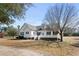 Charming two-story home with a covered front porch, manicured lawn, and mature trees at 589 Loop Circle, Longs, SC 29568