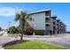 Exterior of condo building with multiple balconies, palm trees, landscaped yard, and street views at 6000 N Ocean Blvd. # 329, North Myrtle Beach, SC 29582