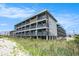 Exterior of condo building on stilts from beachside with balconies and landscaped yard at 6000 N Ocean Blvd. # 329, North Myrtle Beach, SC 29582