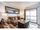 Comfortable living room features a leather sofa, wood-look floors and sliding doors to a balcony at 6000 N Ocean Blvd. # 329, North Myrtle Beach, SC 29582