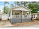 Charming exterior with a cozy porch, white picket fence, and a shed at 6001 - 1498 S Kings Hwy., Myrtle Beach, SC 29575
