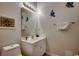 Well-lit half bathroom with a white vanity, toilet, framed art, and decorative fish at 601 Hillside Dr. N # 3704, North Myrtle Beach, SC 29582