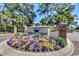Community entrance sign amidst colorful flowers, lush greenery, and brick accents at 601 Hillside Dr. N # 3704, North Myrtle Beach, SC 29582
