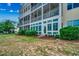 Expansive building exterior featuring multiple screened porches and a ground floor enclosed sunroom with bright light at 601 Hillside Dr. N # 3704, North Myrtle Beach, SC 29582