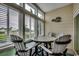 The sunroom's dining area includes a round table and comfortable seating, surrounded by windows and views of the outdoors at 601 Hillside Dr. N # 3704, North Myrtle Beach, SC 29582