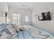 Bedroom with door to the exterior and vaulted ceiling, featuring shutters and a wall-mounted television at 603 Wave Rider Ln. # 603, North Myrtle Beach, SC 29582