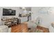 Bright living room with hardwood floors and white decor with dining table and television at 603 Wave Rider Ln. # 603, North Myrtle Beach, SC 29582