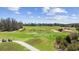 Scenic golf course view with golfers, manicured greens, sand traps, and golf carts under a sunny sky at 6203 Catalina Dr. # 212, North Myrtle Beach, SC 29582
