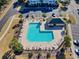 Aerial view of community pool, surrounded by palm trees, seating and parking at 6203 Catalina Dr. # 212, North Myrtle Beach, SC 29582