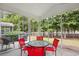 Inviting screened porch with red chairs, a table and backyard golf course views at 6203 Catalina Dr. # 212, North Myrtle Beach, SC 29582