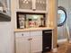 Wet bar area with white cabinets, a mini-fridge, and decorative beach-themed accents at 701 Norris Dr., Pawleys Island, SC 29585