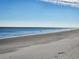 Expansive beach with sand and blue ocean water meeting a clear blue sky at 701 Norris Dr., Pawleys Island, SC 29585