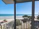 Beautiful view of the beach and ocean from the screened-in porch, framed by lush palm trees and serene blue skies at 701 Norris Dr., Pawleys Island, SC 29585