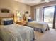 Cozy bedroom with two twin beds, coastal decor, and sliding glass doors leading to a balcony at 701 Norris Dr., Pawleys Island, SC 29585