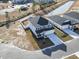 Aerial view of a new construction home featuring a gray exterior, long driveway and community pond at 7094 Watercress St, Myrtle Beach, SC 29579