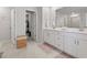 Bright bathroom featuring a double vanity, neutral tile, and a walk-in closet for ample storage at 7094 Watercress St, Myrtle Beach, SC 29579