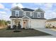 Charming two-story home featuring a two-car garage and a welcoming front porch with stylish seating at 7094 Watercress St, Myrtle Beach, SC 29579