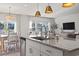 Island sink highlights modern kitchen open to dining and living room, showcasing open-concept design with bright natural light at 7094 Watercress St, Myrtle Beach, SC 29579