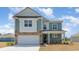 Charming two-story home featuring a stone-accented facade, attached garage, and a welcoming front porch at 744 Choctaw Dr., Conway, SC 29526