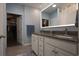 Bathroom with dual sinks, granite countertop, lighted mirror, and walk-in closet access at 797 Salerno Circle # C, Myrtle Beach, SC 29579