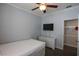 Bedroom with wood floors, dresser, bed, ceiling fan, and mounted TV near a closet at 797 Salerno Circle # C, Myrtle Beach, SC 29579