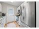Charming kitchen with stainless steel refrigerator, white cabinets, and a door leading outside at 820 9Th Ave. S, North Myrtle Beach, SC 29582