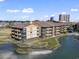Attractive marsh-front condo building boasts private balconies, lush landscaping, and coastal charm under a sunny sky at 9501 Shore Dr. # A-311, Myrtle Beach, SC 29572