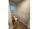 This bathroom features a toilet, a window and wood-look flooring at 1064 Oak Meadow Dr., Conway, SC 29526