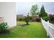 Green backyard featuring verdant lawn, mature trees, and a classic white picket fence at 112 Molinia Dr., Murrells Inlet, SC 29576