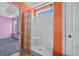Bright bathroom featuring a shower with a curtain, accented by orange walls and a glimpse into a bedroom at 1220 Dunraven Ct., Conway, SC 29527