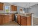 Cozy kitchen showcasing wooden cabinets, stainless steel appliances and a view into the adjacent dining area at 1220 Dunraven Ct., Conway, SC 29527