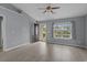Bright living room with wood-look flooring, ceiling fan, and natural light from the front door and large window at 1220 Dunraven Ct., Conway, SC 29527