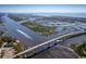Scenic aerial view of a coastal waterway with a bridge, coastline, and boats at 1308 Piper Glen Dr, Sunset Beach, NC 28468