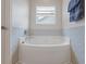 Bathroom showcasing a large soaking tub with tile surround and a bright window at 131 Crabapple Dr., Longs, SC 29568