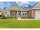 Inviting single-story home featuring a covered porch and manicured landscaping at 131 Crabapple Dr., Longs, SC 29568