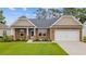 Charming brick home featuring well-maintained landscaping and an attached two-car garage at 131 Crabapple Dr., Longs, SC 29568