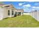 Lovely backyard features a patio area with a grill, a white fence, and lush green grass at 135 Maggie Way, Myrtle Beach, SC 29588