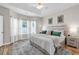 Bright main bedroom featuring a tray ceiling, neutral walls, and windows with sheer curtains at 135 Maggie Way, Myrtle Beach, SC 29588