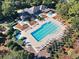 Aerial view of the large pool with a hot tub, the club house, and lots of outdoor seating at 1550 Spinnaker Dr. # 3123, North Myrtle Beach, SC 29582