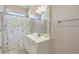 Bright bathroom features a shower with patterned curtain, single sink with white vanity, and neutral paint at 1613 Havens Dr., North Myrtle Beach, SC 29582